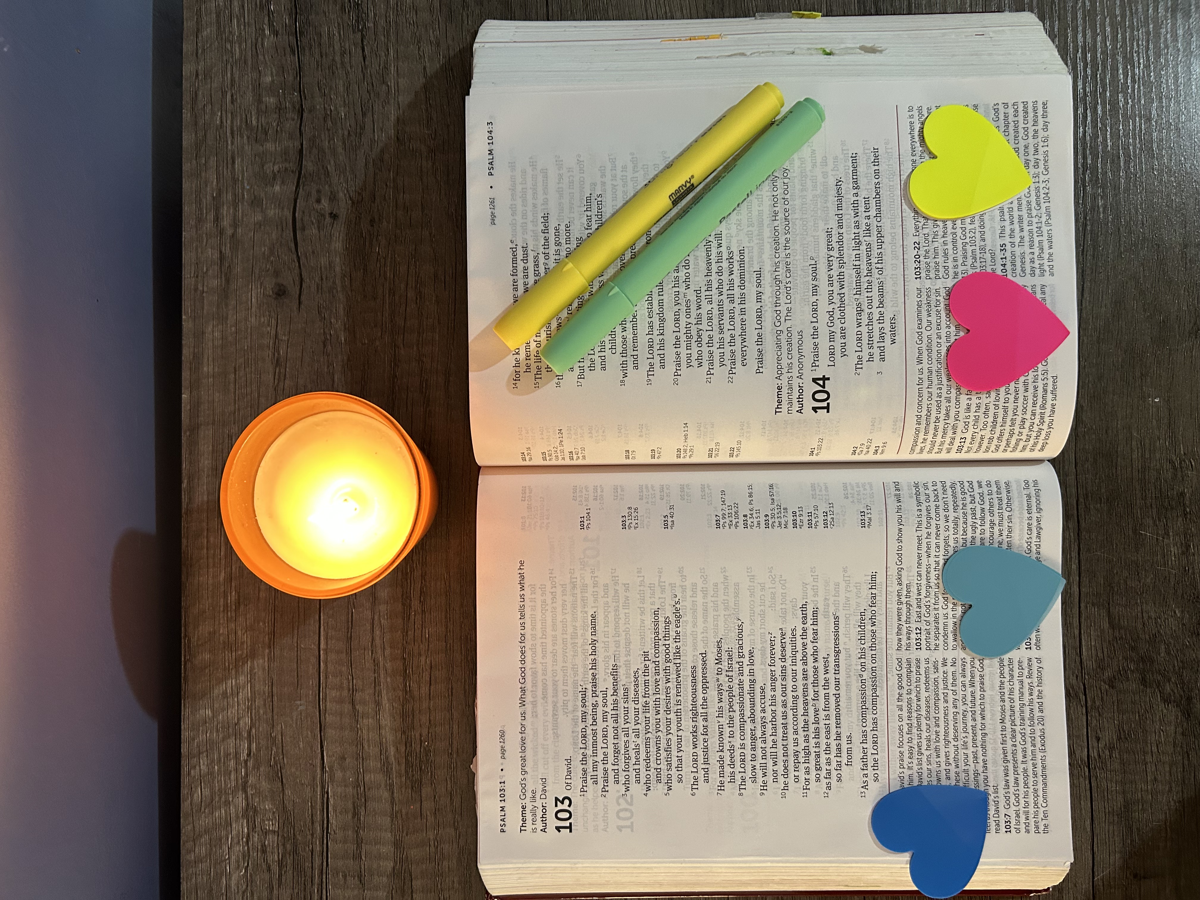 Open Bible with candle, highlighters, and heart-shaped notes